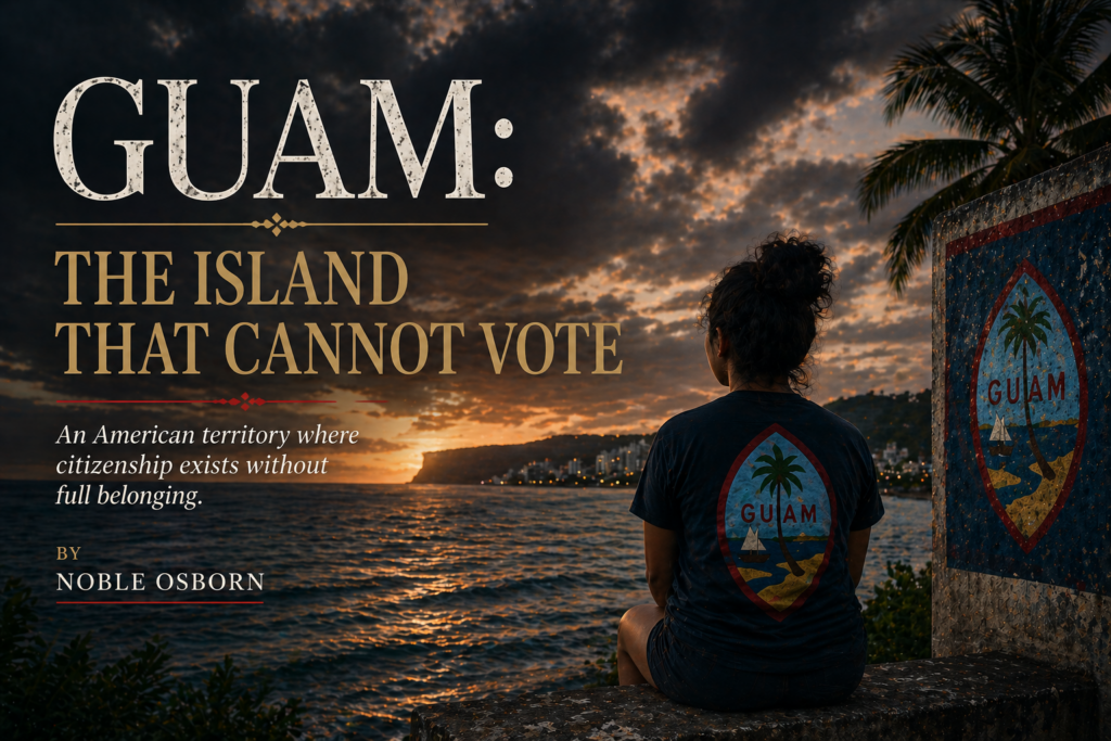 A cinematic coastal scene at sunset shows a lone figure seated on a weathered concrete wall overlooking the ocean, facing a distant shoreline city under heavy clouds. A Guam seal is painted on a nearby structure and echoed on the figure’s shirt. Overlaid text reads: “GUAM: THE ISLAND THAT CANNOT VOTE” with the subtitle “An American territory where citizenship exists without full belonging,” and a byline beneath. The tone is somber, reflective, and political, emphasizing isolation and constrained identity.